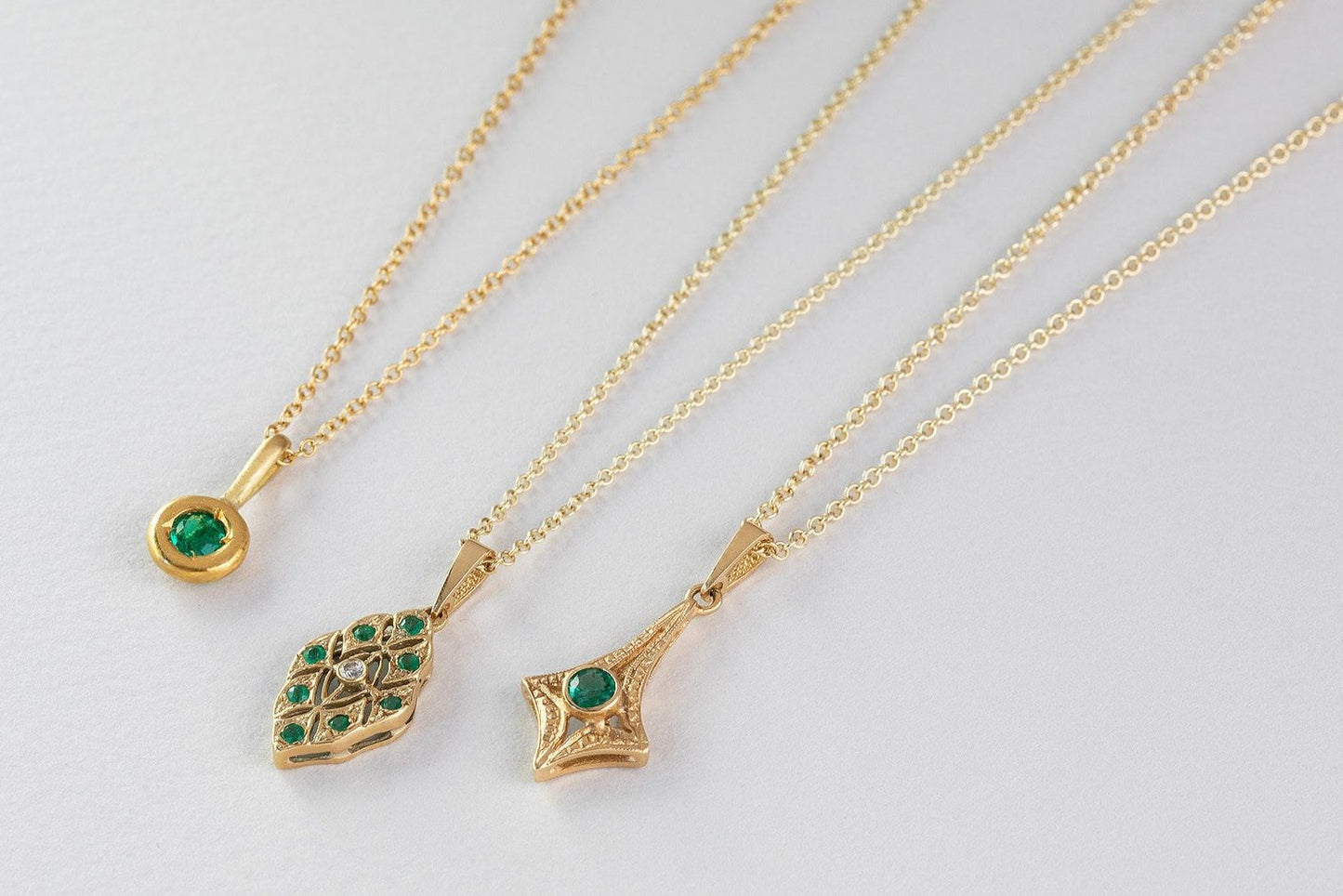 שרשרת זהב מרהיבה עם תליון קמע עין מזהב משובץ כולו יהלומים ובמרכז אבן אמרלד ירוקה