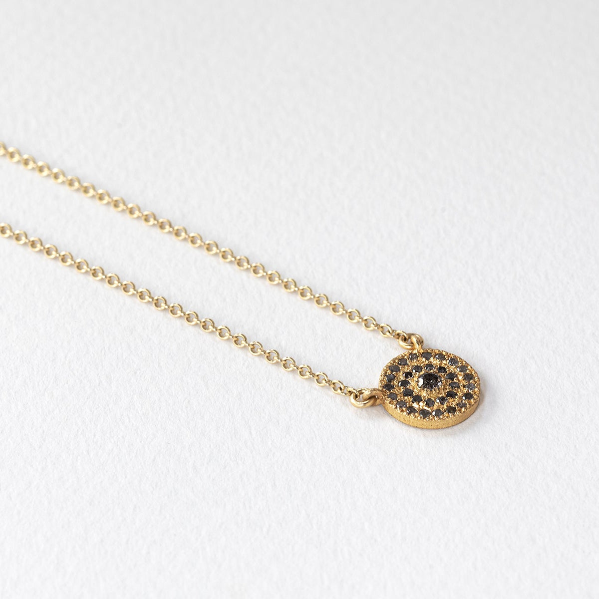 שרשרת זהב מיוחדת שבמרכזה עיגול הב מרשים שעליו משובצים מעגלים של יהלומים אפורים