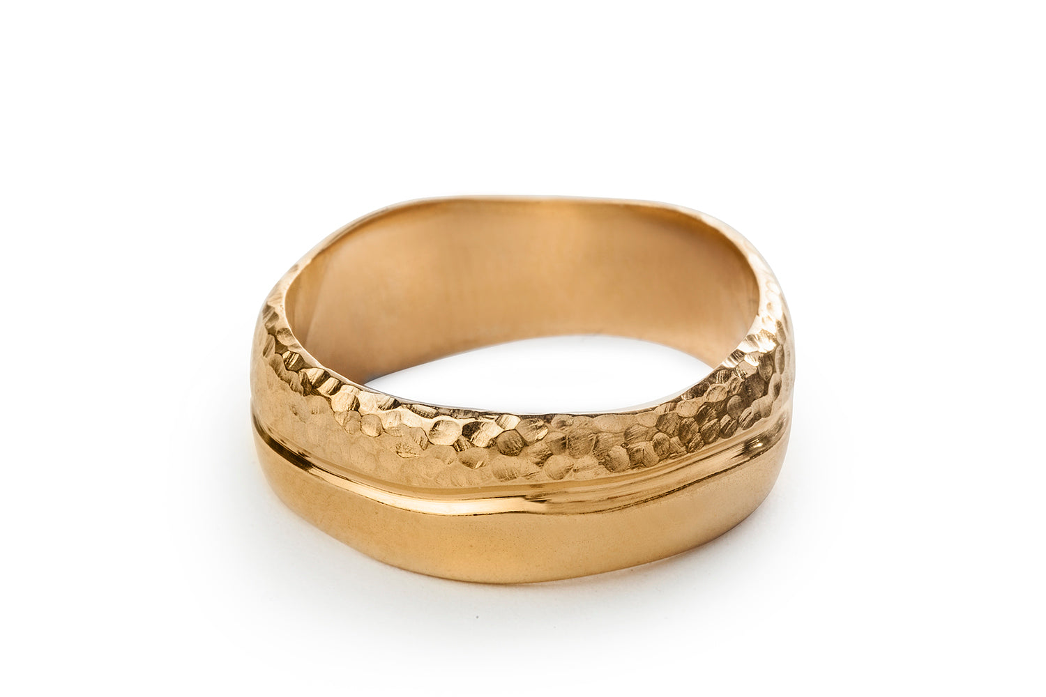 טבעת יוניסקס רחבה. טבעת זהב עשויה בעבודת יד בסטודיו שלנו, הטבעת מעוגלת קלות ובמרכזה עובר קו גלי שחרוט בתוך החומר. חצי מהטבעת בגימור מבריק וחציה השני מובלט על ידי טקסטורה מחוספסת.