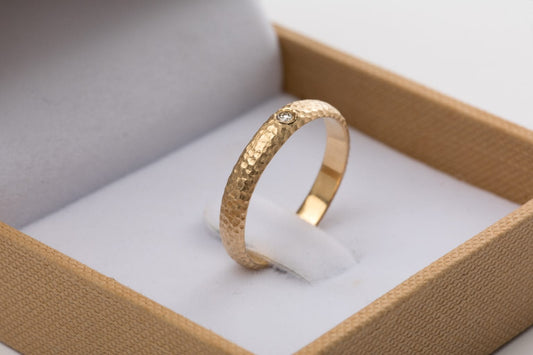 טבעת זהב מרשימה עשויה בעבודת יד אישית עם טקסטורת ריקוע ירח ייחודית. הטבעת בעלת מבנה מעוגל ומשובצת ביהלום עגול מנצנץ