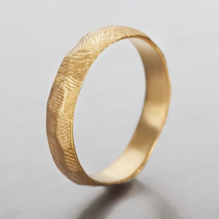 טבעת נישואים לגבר  מעוצבת ועשויה בעבודת יד. טבעת סלע עשויה זהב מהוב ובעלת מבנה ייחודי לא אחיד עם טקסטורה הנראית כמו פני שטח של סלע.