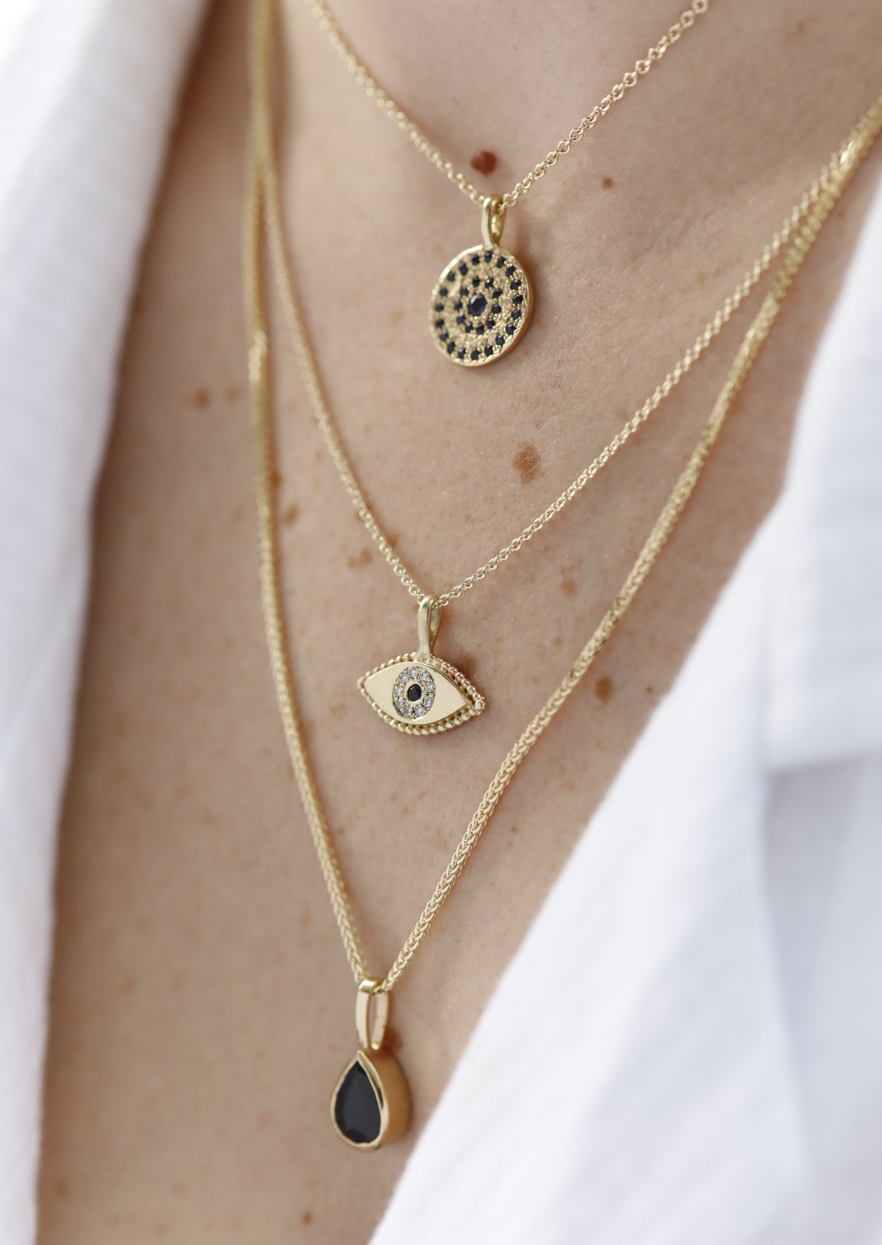 שרשרת זהב עם תליון עיגול זהב בצורת מטבע משובצת במעגלים של ספירים כחולים