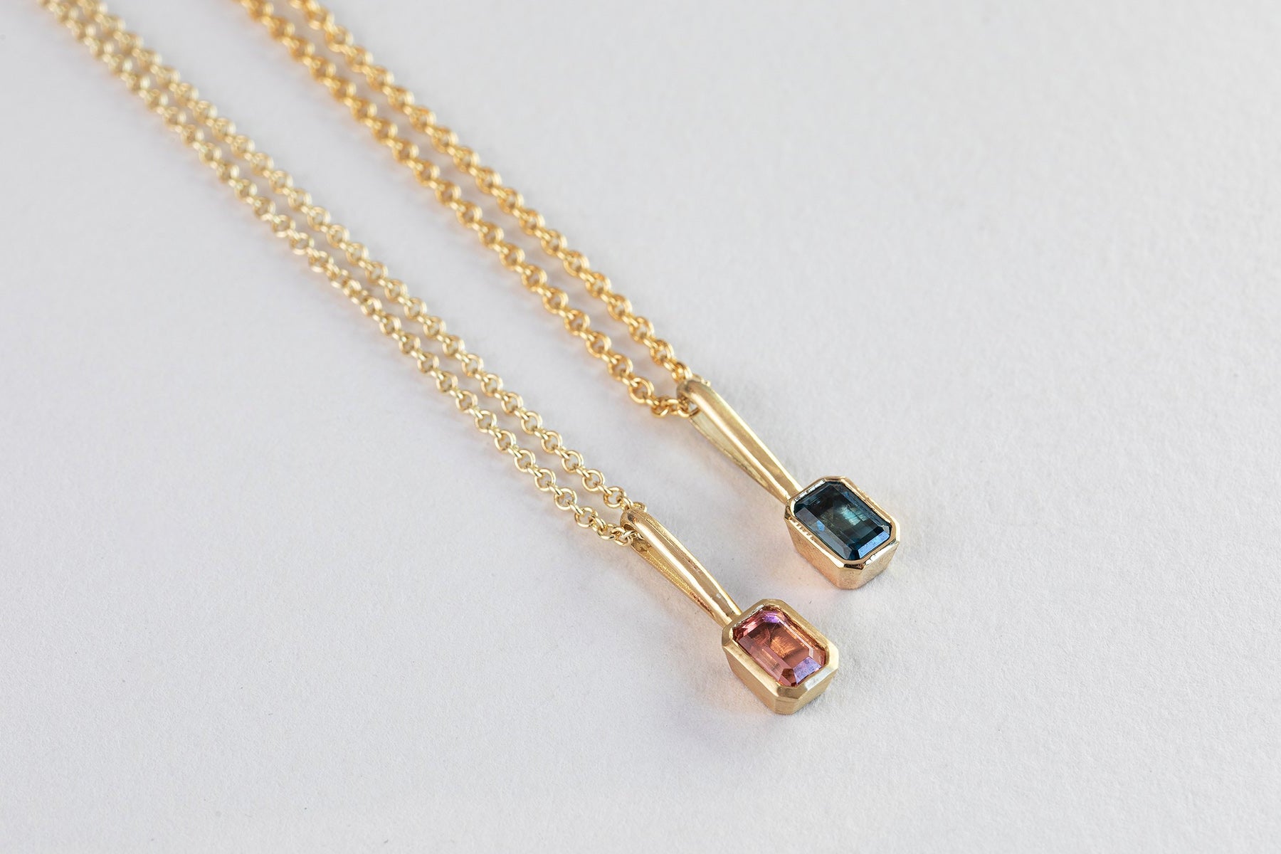 שרשרת חוליות זהב עדינות ותליון זהב עם וו ארוך בצורת מלבן משובץ טורמלין כחול. ושרשרת חוליות זהב ותליון מלבן משובצת טורמלין וורוד