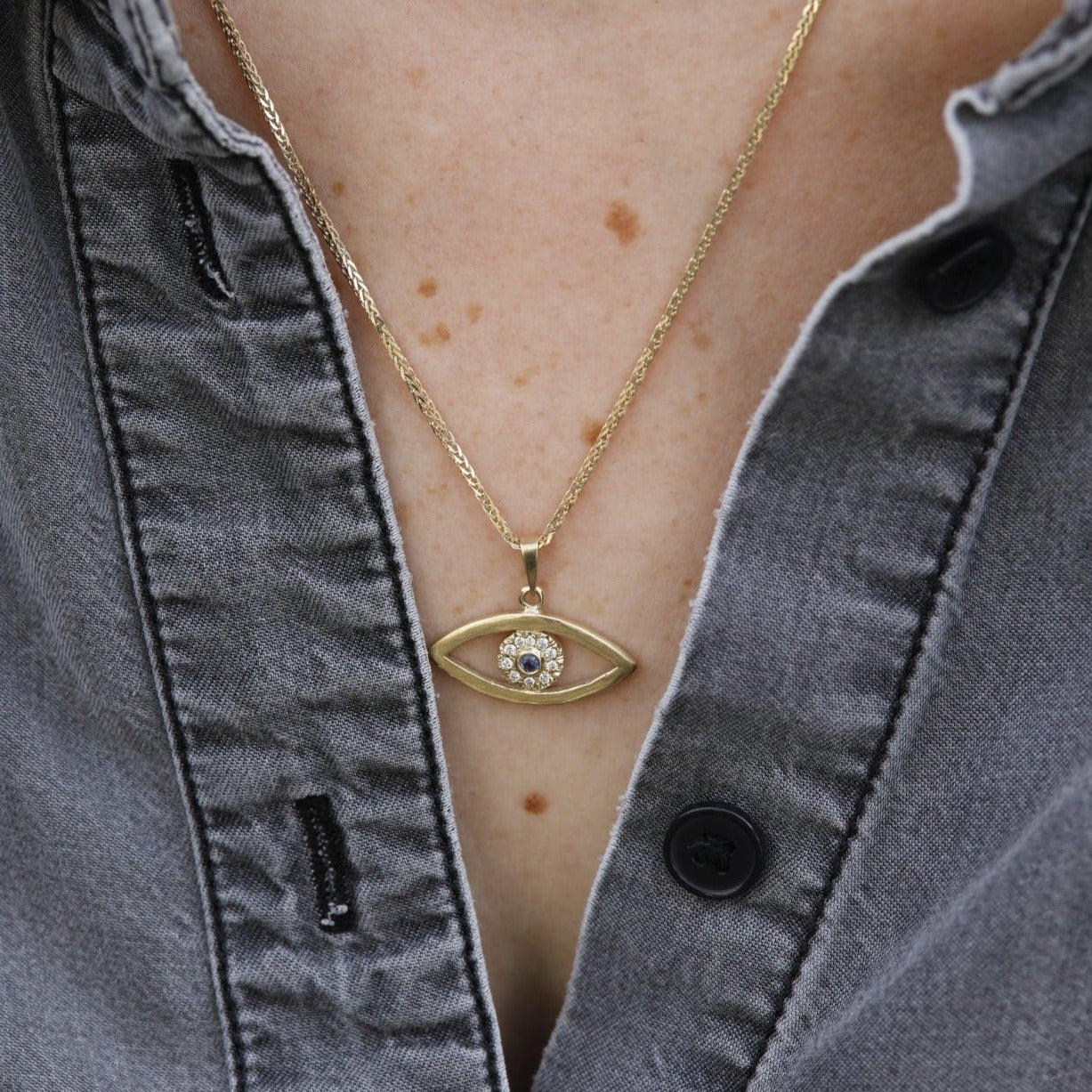 שרשרת עין מזהב. תליון עין גדולה עשויה בעבודת יד משובצת במרכז יהלומים וספיר.