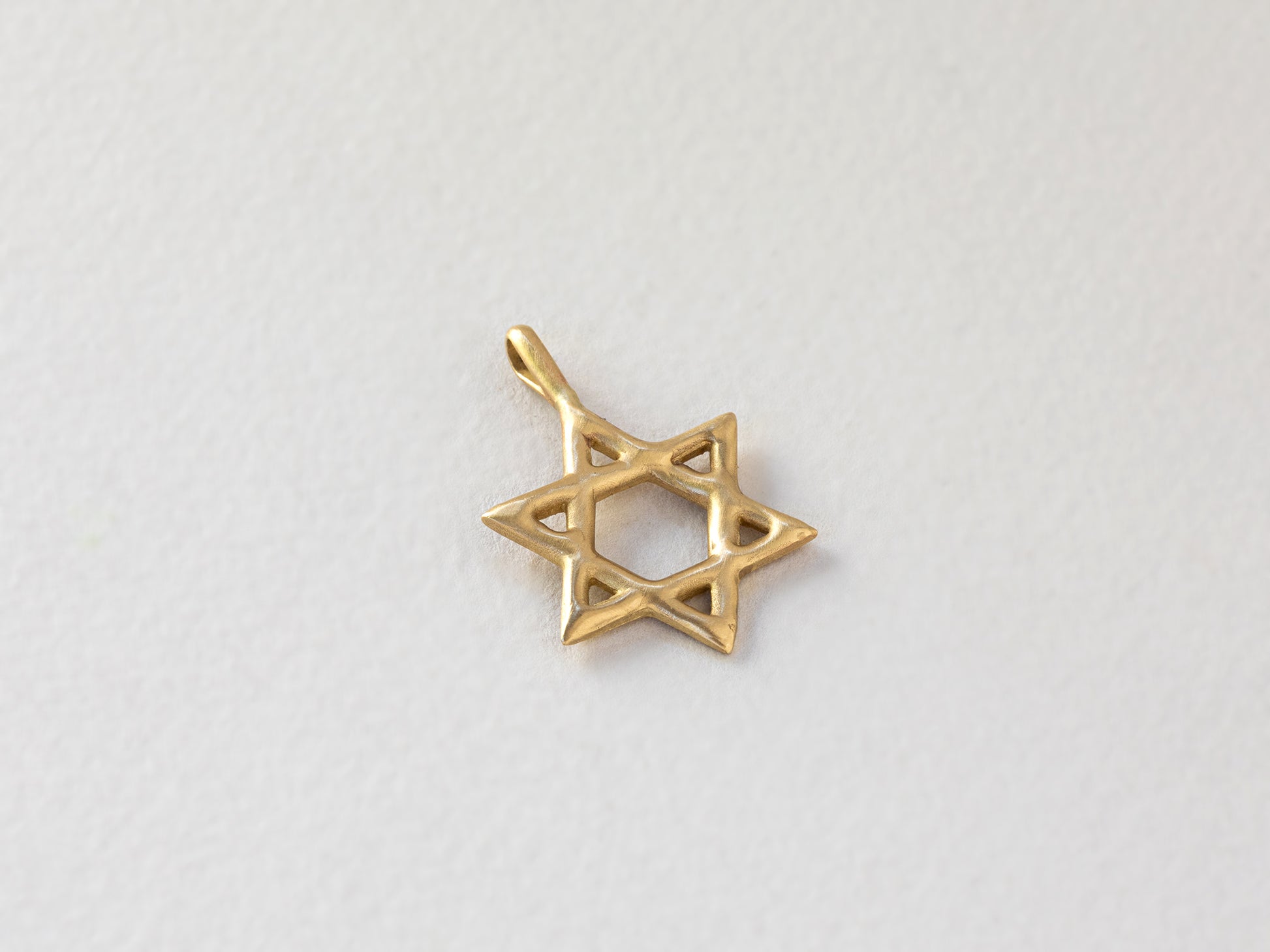 תליון מגן דוד זהב מיוחד. עשוי זהב 14 קראט, מפוסל בעבודת יד במראה גולמי