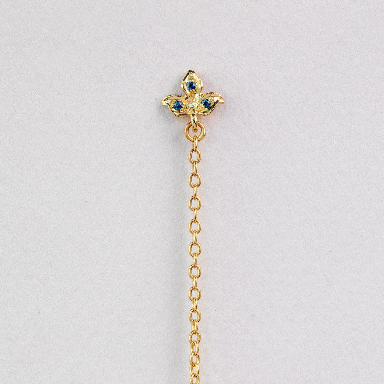 עגיל זהב מעוצב עם עלה תלתן זהב משובץ בלו טופז ושרשרת ארוכה