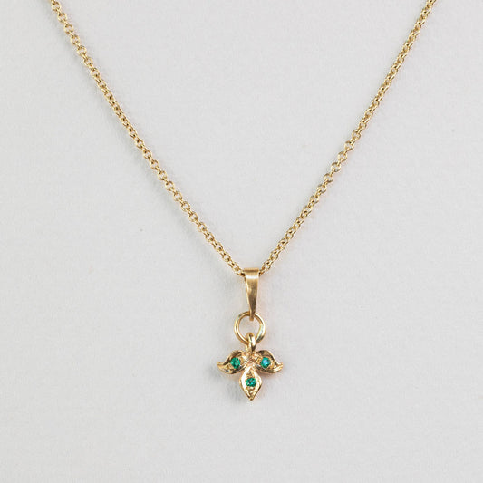 שרשרת זהב עדינה עם תליון עלה זהב משובץ בשלושה אבני אמרלד ירוקות.