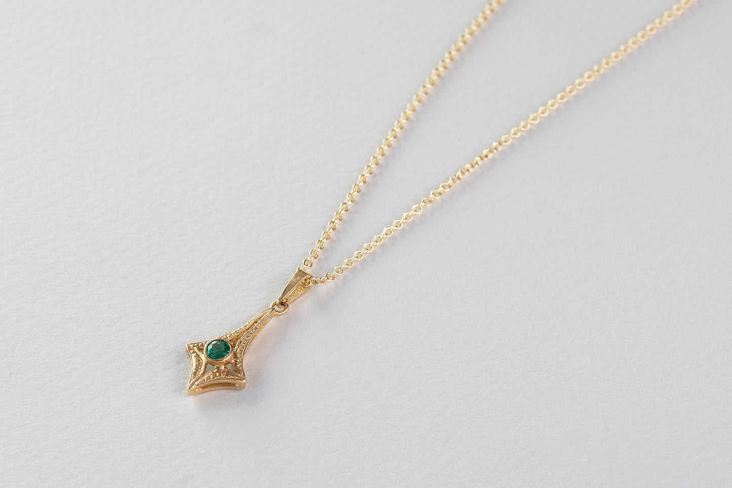 שרשרת זהב מרהיבה עם תליון קמע עין מזהב משובץ כולו יהלומים ובמרכז אבן אמרלד ירוקה