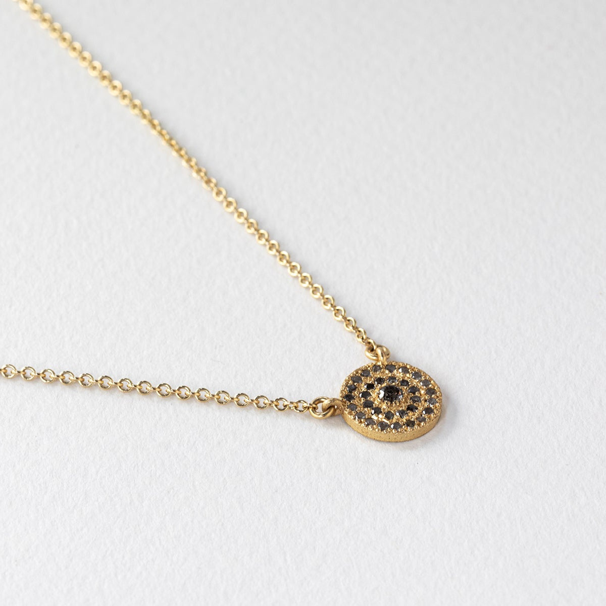 שרשרת זהב מיוחדת שבמרכזה עיגול הב מרשים שעליו משובצים מעגלים של יהלומים אפורים