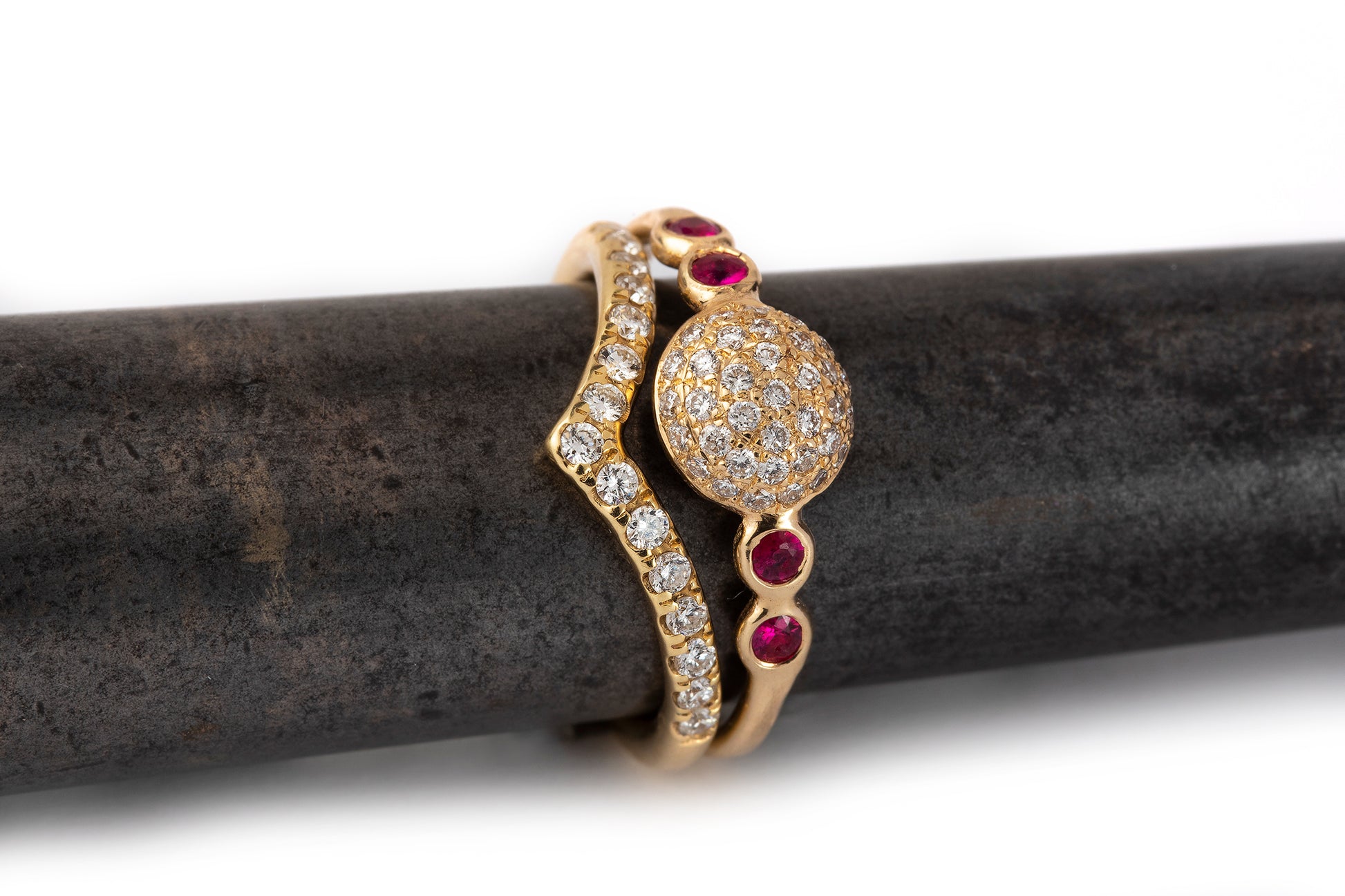 טבעת בצורת וי זהב משובץ יהלומים לצד טבעת גלקסיה משובצת יהלומים ואבני רובי