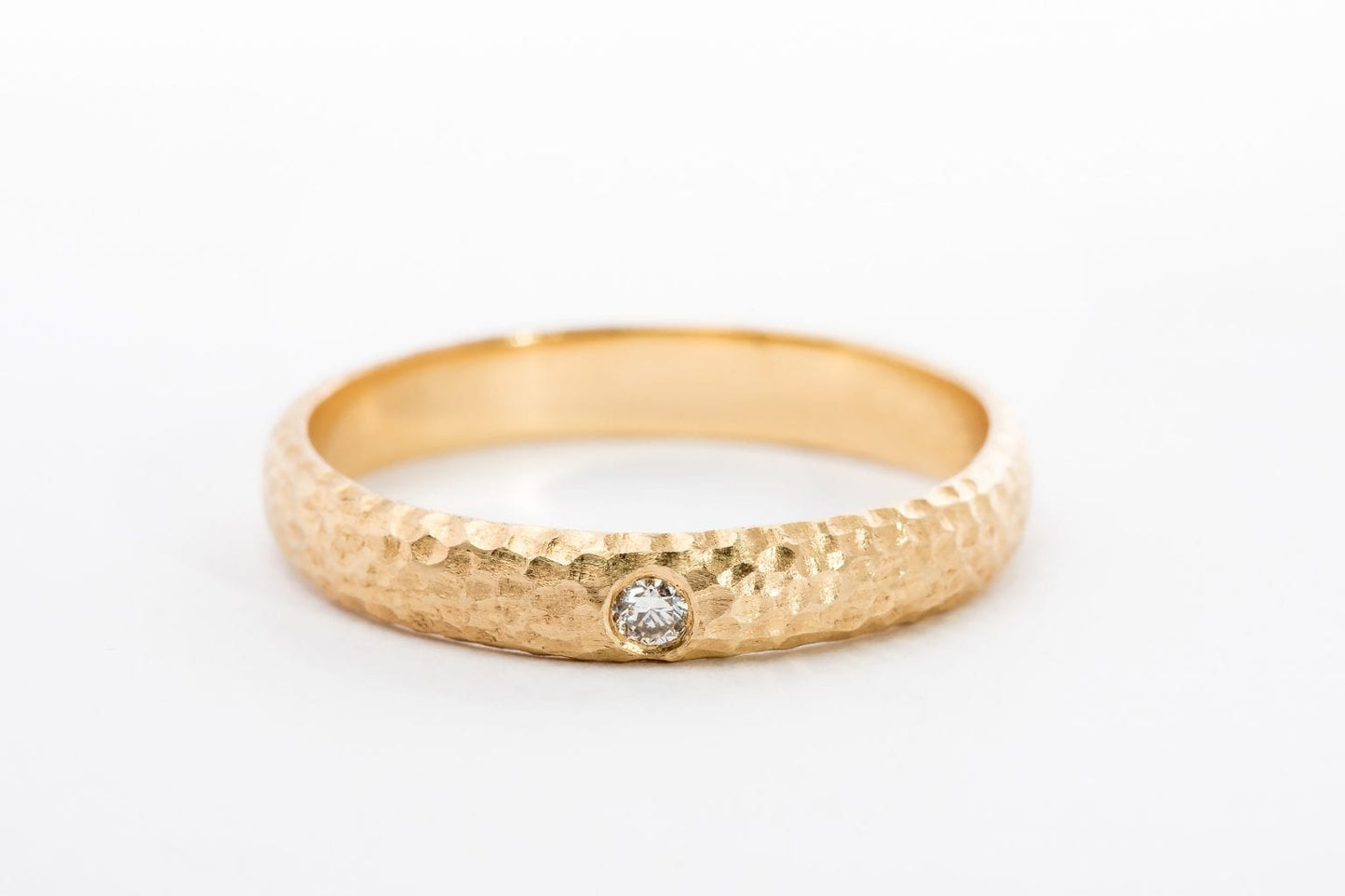 טבעת זהב מרשימה עשויה בעבודת יד אישית עם טקסטורת ריקוע ירח ייחודית. הטבעת בעלת מבנה מעוגל ומשובצת ביהלום עגול מנצנץ