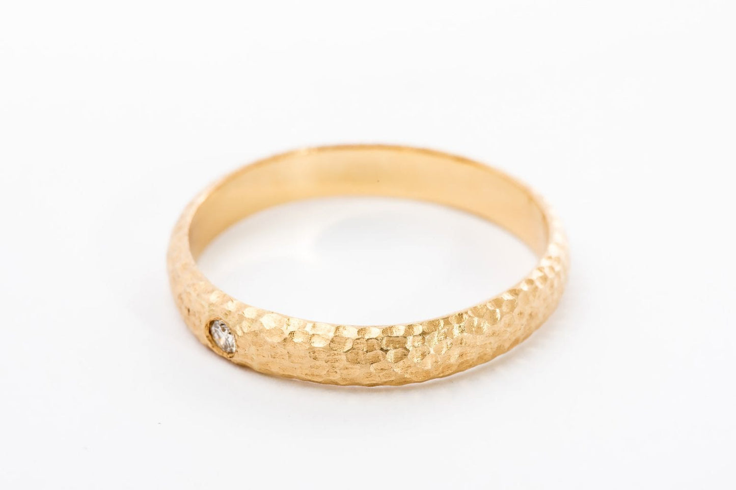 טבעת זהב מרשימה עשויה בעבודת יד אישית עם טקסטורת ריקוע ירח ייחודית. הטבעת בעלת מבנה מעוגל ומשובצת ביהלום עגול מנצנץ