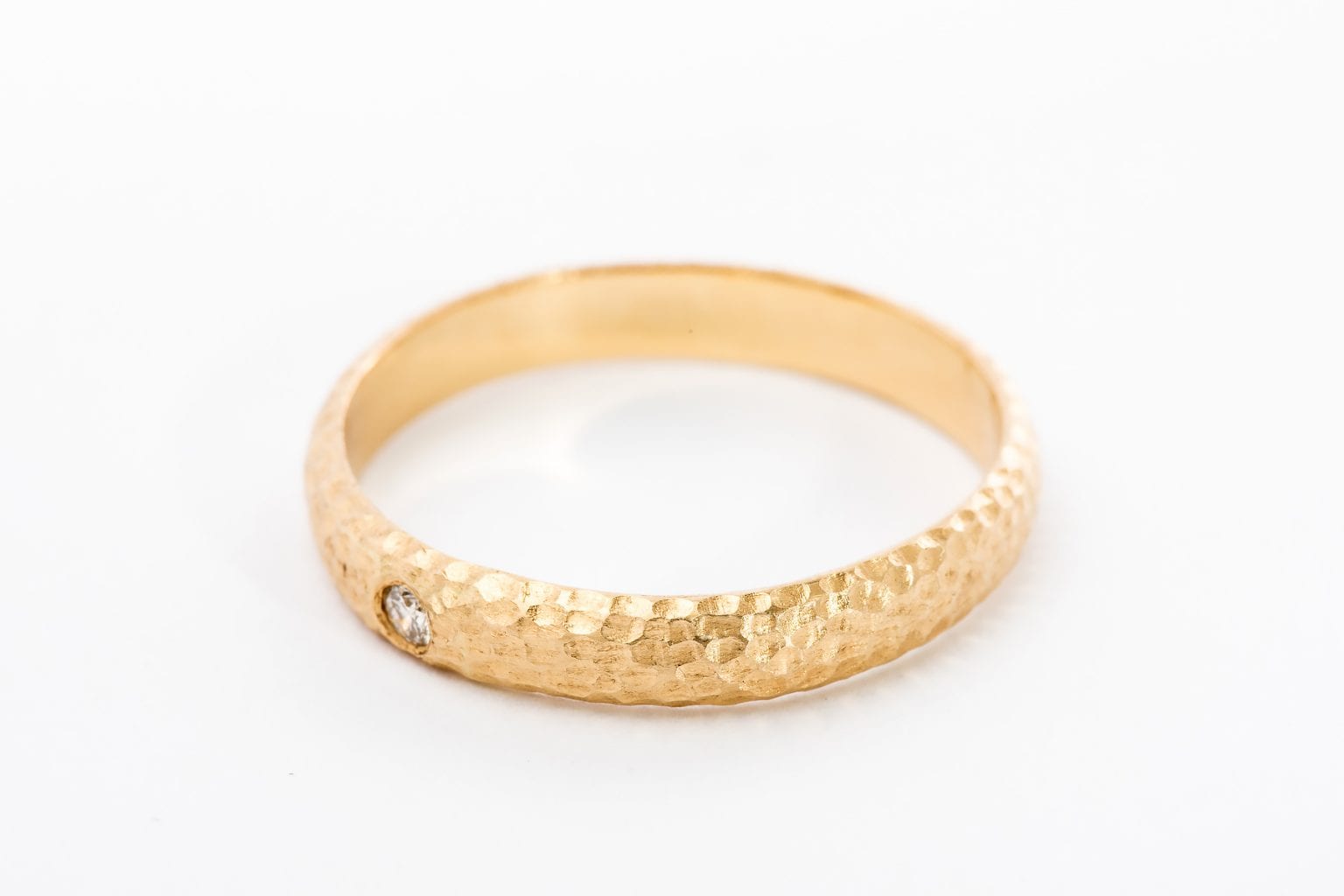 טבעת זהב מרשימה עשויה בעבודת יד אישית עם טקסטורת ריקוע ירח ייחודית. הטבעת בעלת מבנה מעוגל ומשובצת ביהלום עגול מנצנץ