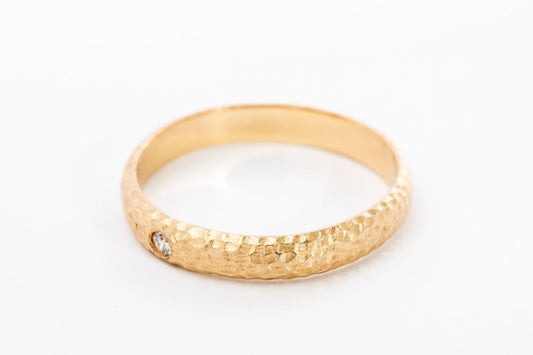 טבעת זהב מרשימה עשויה בעבודת יד אישית עם טקסטורת ריקוע ירח ייחודית. הטבעת בעלת מבנה מעוגל ומשובצת ביהלום עגול מנצנץ