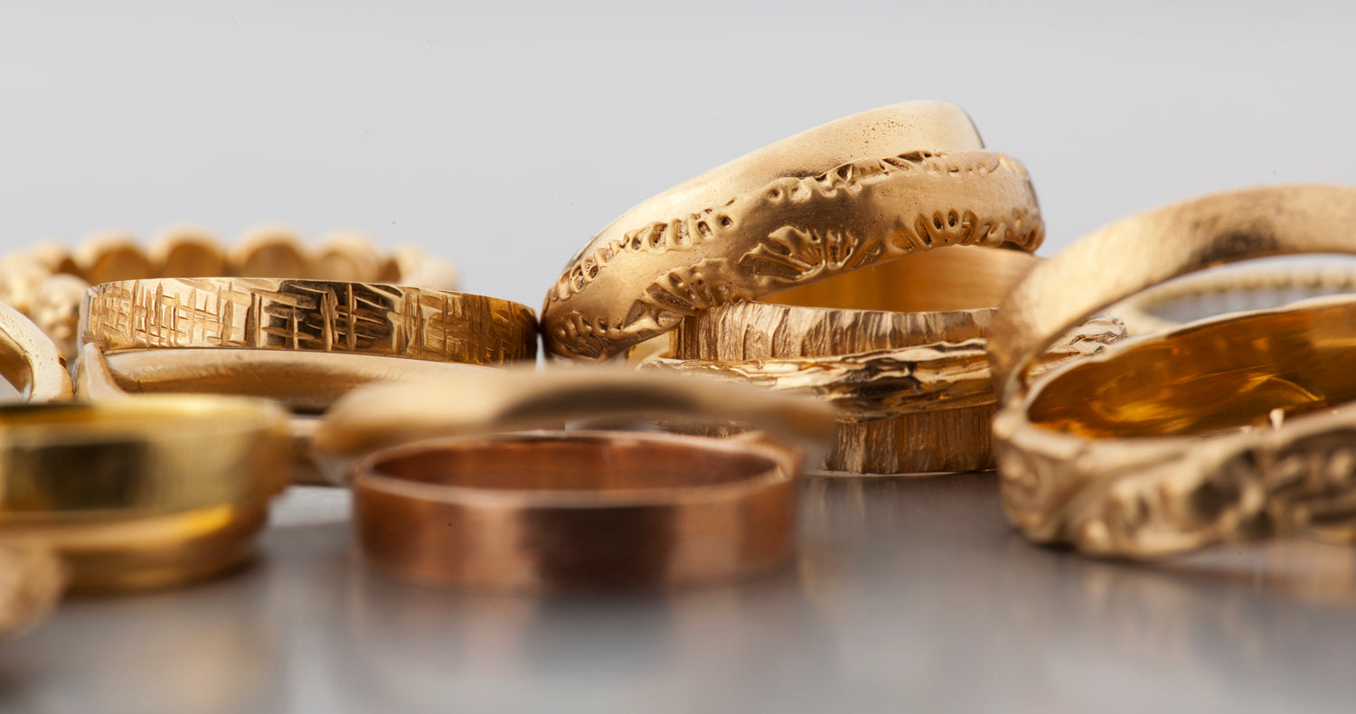 טבעת זהב בעבודת יד במבנה לא אחיד משתנה עם שוליים שמדמים כרסום בזהב.