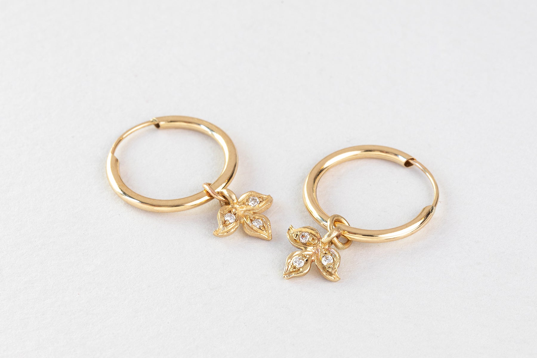 עגילי חישוק זהב קטן עם תליון עלה תלתן משובץ יהלומים