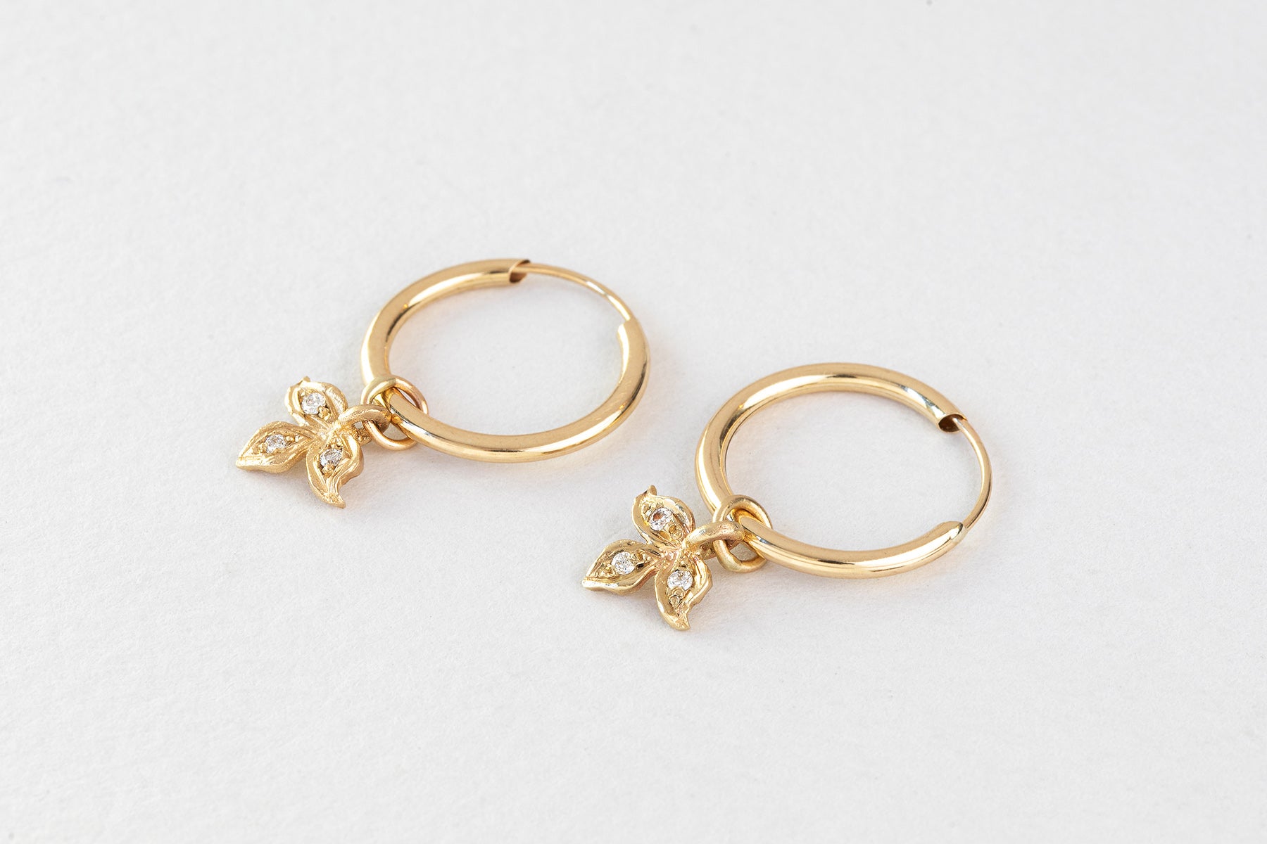 עגילי חישוק זהב קטן עם תליון עלה תלתן משובץ יהלומים