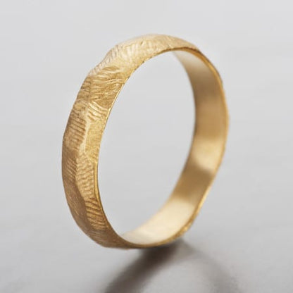 טבעת נישואים לגבר  מעוצבת ועשויה בעבודת יד. טבעת סלע עשויה זהב מהוב ובעלת מבנה ייחודי לא אחיד עם טקסטורה הנראית כמו פני שטח של סלע. 