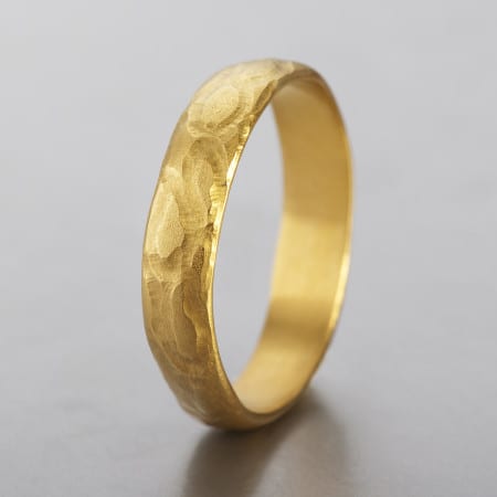 טבעת נישואים מיוחדת יוניסקס לגבר ולאישה. עשויה בעבודת יד טבעת זהב חצי עגולה עם טקסטורה מנומרת יחודית