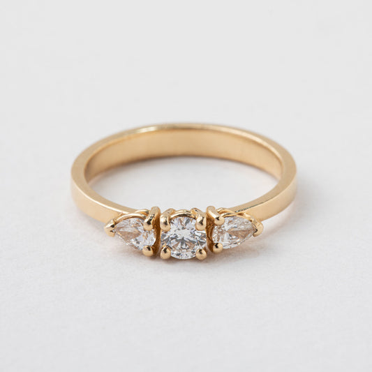 טבעת זהב בסגנון וינטאג׳ משובצת יהלומי מעבדה. במרכז יהלום מעבדה עגול ובשני הצדדים יהלומי מעבדה בחיתוך טיפה