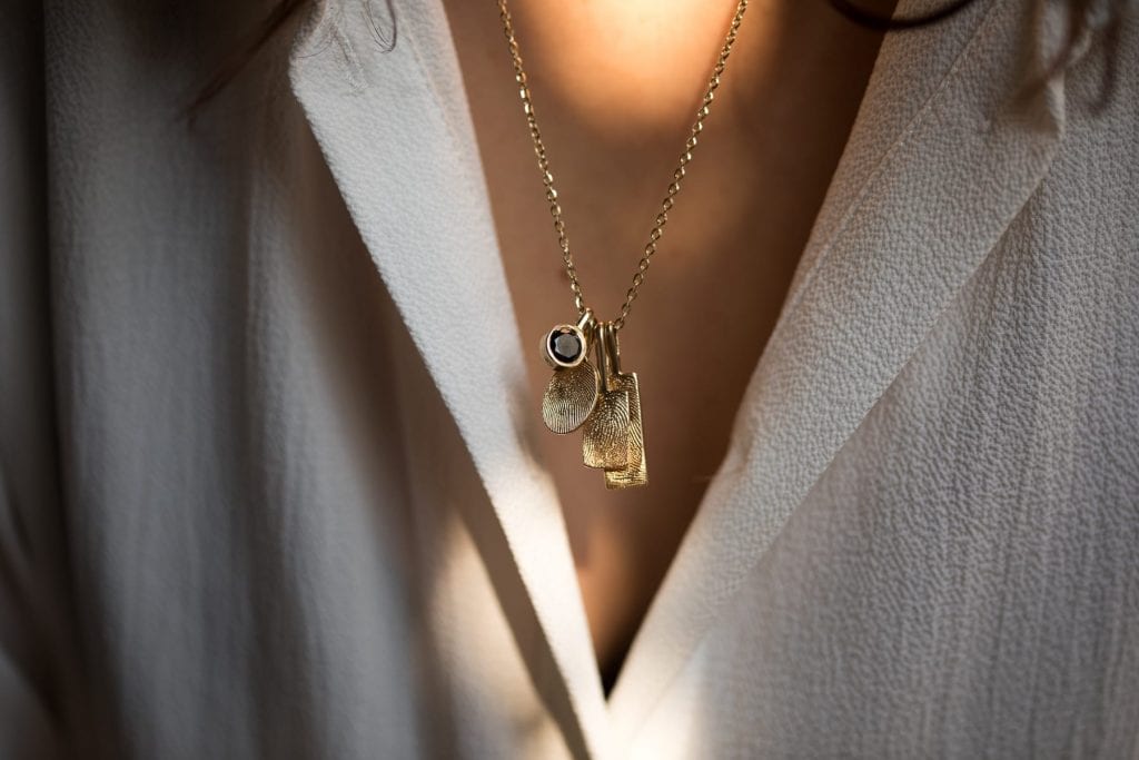 שרשרת טביעות אצבע מזהב. שילוב תליוני זהב עם טביעות אצבע אישיות ותליון אבן ספינל שחורה בכוס זהב