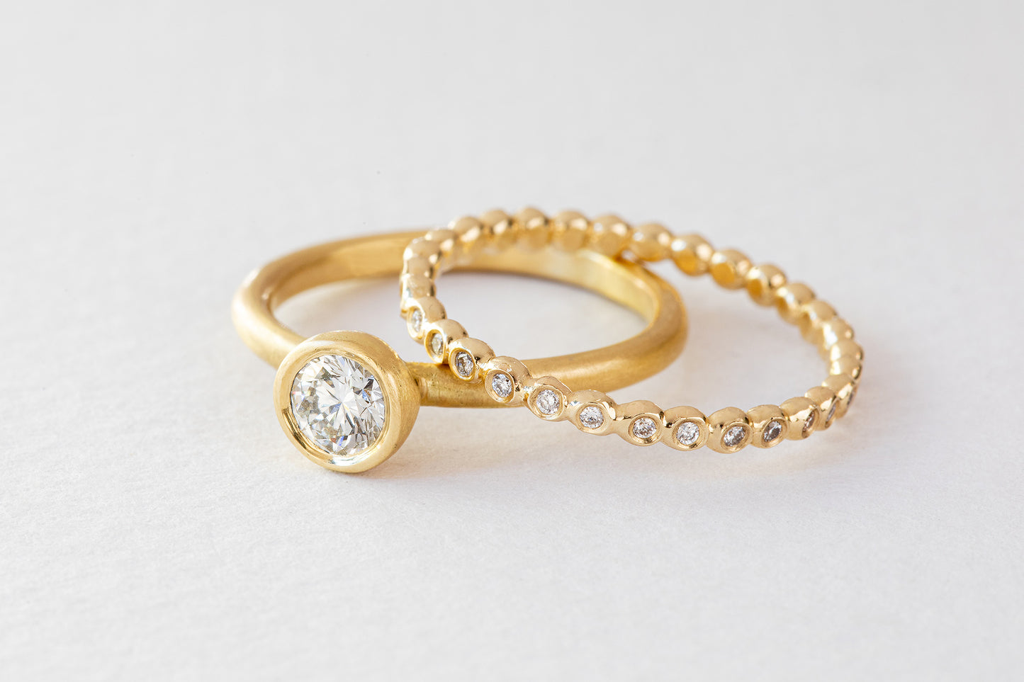 טבעת אירוסין קלאסית משובצת יהלום מעבדה  במראה בוהו וגימור מט יחד עם טבעת כדורים קטנה מזהב משובצת יהלומי מעבדה