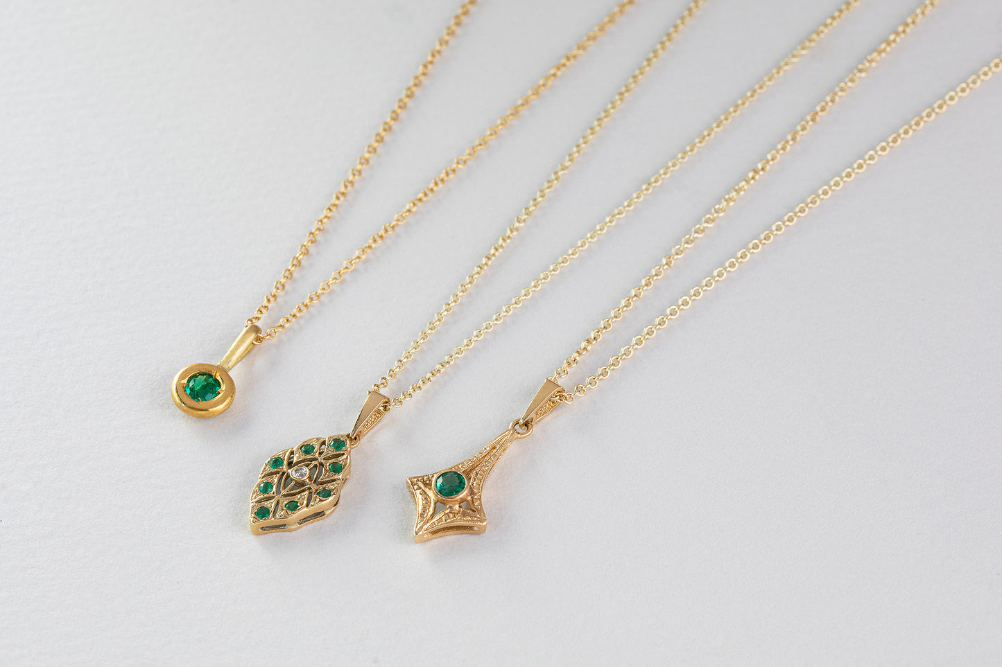 שרשרת זהב וינטאג׳ עם תליון מעויין תחרה משובץ אבני אמרלד ויהלום
יחד עם שרשרת עם תליון כוס זהב משובץ אמרלד.
ושרשרת זהב עם תליון וינטאג׳ משובץ אמרלד.
