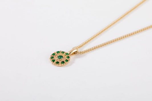 שרשרת זהב עם תליון עיגול זהב עדין משובץ מעגל אמרלדים ואמרלד נוסף באמצע
