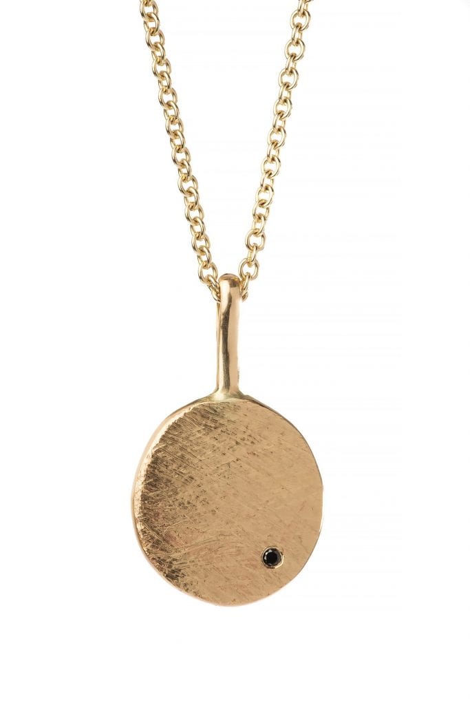 שרשרת זהב עם תליון בצורת מטבע זהב שעליו משובצת אבן יהלום שחור עדינה. המטבע מחובר עם וו זהב. 