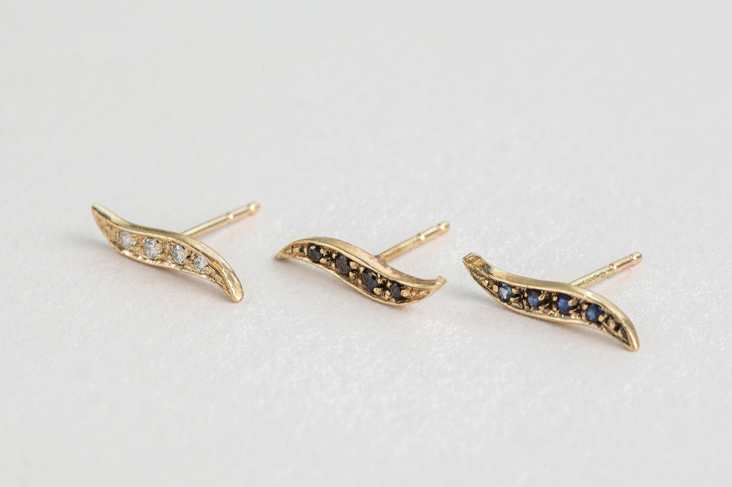 שלישיית עגילי זהב בצורת גל משובצים אבני ספיר, יהלומים ויהלומים שחורים