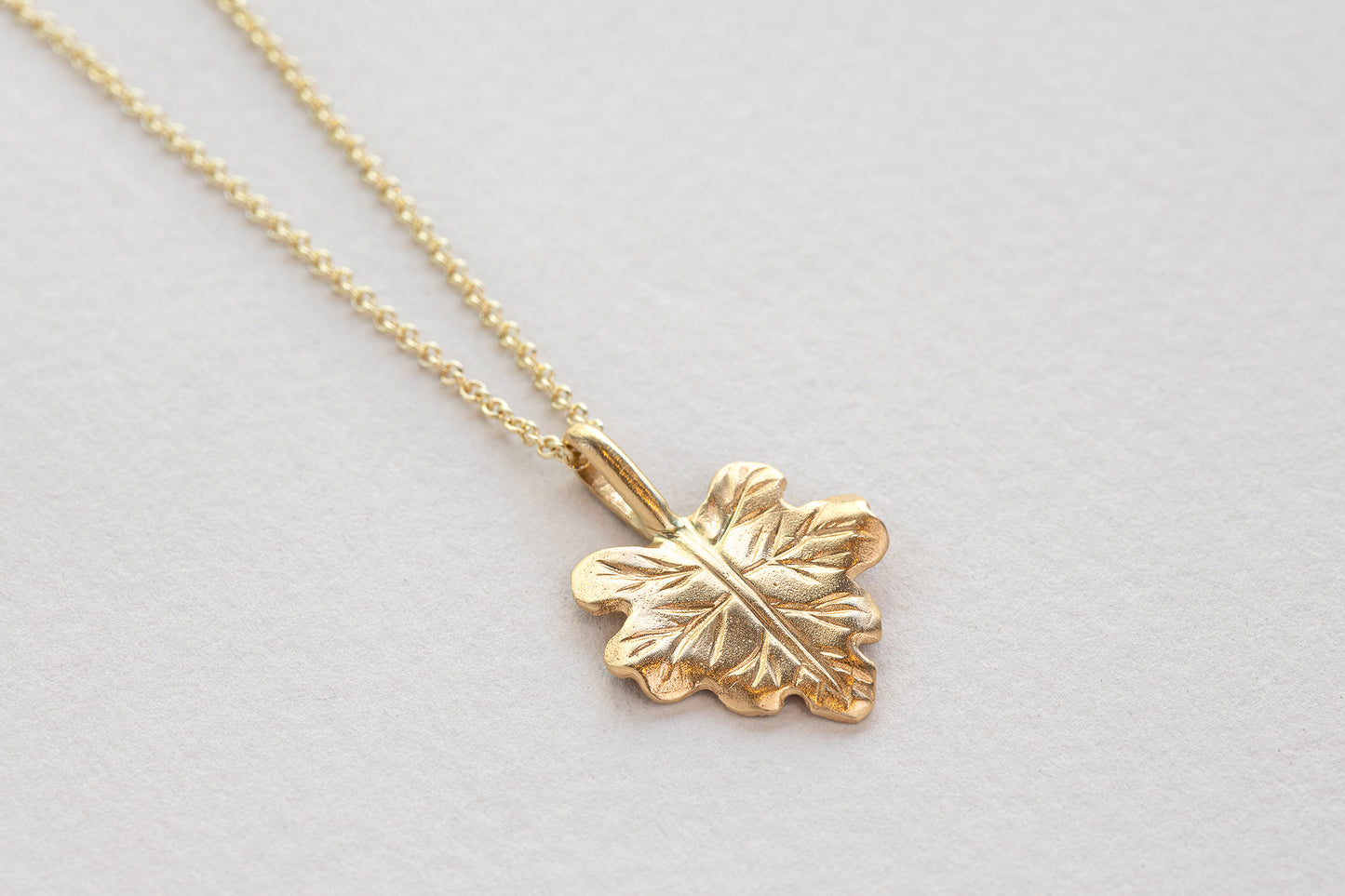 שרשרת עלה גפן בעבודת יד. מפוסלת בזהב וייצוקה בזהב. תליון עלה גפן זהב מושחל על שרשרת חוליות זהב עדינה